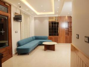 a living room with a blue couch and a table at Vardhn Villa in Sarāhan