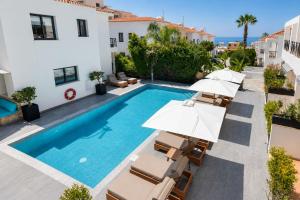 an image of a swimming pool with umbrellas and chairs at Julipapas Gardens in Paphos