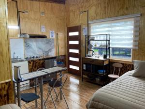 a bedroom with a bed and a desk with a computer at Departamentos Eldestino in Puerto Puyuhuapi