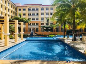 a swimming pool in front of a building at A cozy modern design Unit 6425 in Cebu City