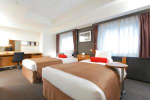 a hotel room with two beds and a desk at HOTEL MYSTAYS Kamata in Tokyo