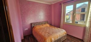 a bedroom with a bed in a pink room with a window at Villa Doda in Durrës