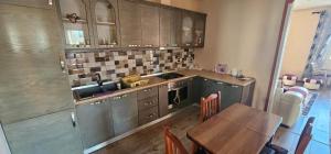 a kitchen with a table and a sink and a counter at Villa Doda in Durrës