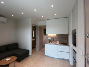 a living room with a couch and a kitchen at Porto Minimal Oasis in Porto Rafti