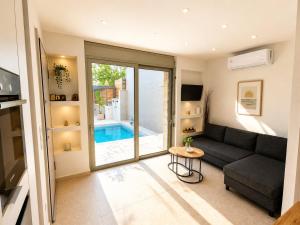 a living room with a couch and a pool at Porto Minimal Oasis in Porto Rafti