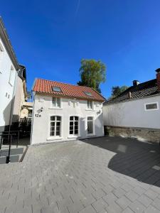 a white building with a red roof at TINY TEUTO HOUSE- Die alte Schusterei in Detmold