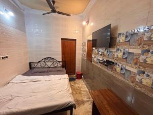 a bedroom with a bed and a flat screen tv at Dee Dash Inn in Bhubaneshwar