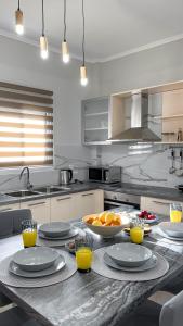 a kitchen with a table with plates and oranges on it at Averto House Lefkada in Lefkada