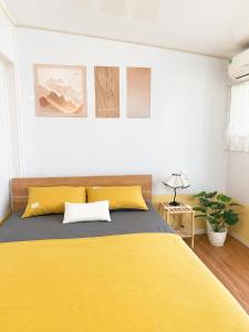 a bedroom with a yellow bed in a room at Lapausa Homestay in Kỳ Vĩ +5 photos