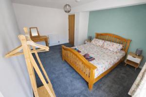 a bedroom with a bed with a wooden frame at Swallows Rest Cottage - 3 Bedrooms - Nr Looe in Looe