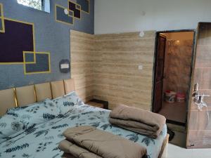 a bedroom with a bed with a comforter on it at Hotel Murlidhar in Chikāra +13 photos