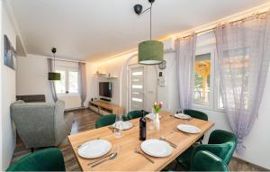 a dining room with a wooden table and green chairs at Apartman in Seline