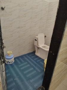 a bathroom with a toilet and a blue floor at Hotel Murlidhar in Chikāra