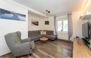 a living room with a couch and a tv at Apartman in Seline