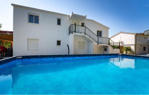 a large blue swimming pool in front of a building at Apartman in Seline