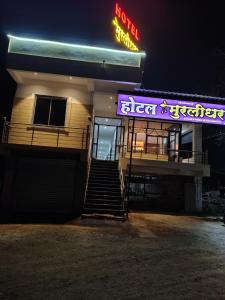 a building with a neon sign on the side of it at Hotel Murlidhar in Chikāra