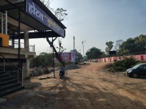 a person walking down a dirt road next to a building at Hotel Murlidhar in Chikāra
