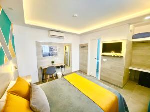 a bedroom with a yellow bed and a desk at DORI ROOMS - Hostal in Tarifa