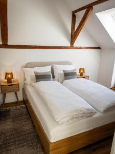a large white bed in a room with two lamps at TINY TEUTO HOUSE- Die alte Schusterei in Detmold