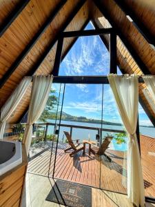 a large window in a house with a view of the water at Chalé com Hidromassagem, Lareira e Piscina na Beira da Lagoa in Imaruí
