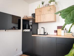 a kitchen with black cabinets and a sink at TINY TEUTO HOUSE- Die alte Schusterei in Detmold +14 photos