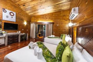 two beds in a room with wooden walls at Baldi Hot Springs Hotel & Spa in Fortuna