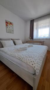 a large bed in a bedroom with a window at Meandar Luxury Apartment in Sarajevo