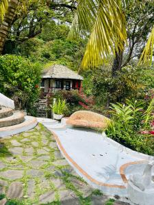 a garden with a small house in the background at Villa La Fortuna Altos del Maria in Filipina