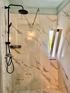 a bathroom with a shower with a sink at Sekretet e Luginës Restaurant - Hostel - Camping in Vau i Dejës