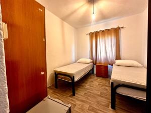 a small room with two beds and a window at Sekretet e Luginës Restaurant - Hostel - Camping in Vau i Dejës
