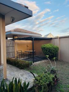a patio with a table in the backyard of a house at The Folkestone Guest House in Gqeberha