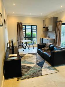a living room with a couch and a table at The Folkestone Guest House in Gqeberha
