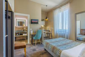 une chambre d'hôtel avec un lit, un bureau et une table dans l'établissement PARMA EXPRESS Traveller's Lodging front Station FS PARKING & Bicycle Storage, à Parme