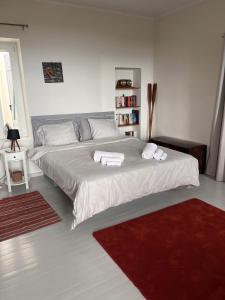 a bedroom with a large bed with towels on it at The Arch House in Kymi