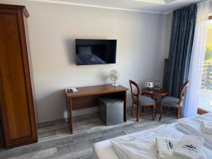 a hotel room with a desk and a table at Pensjonat Nad Rzeką in Wisła