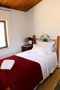 a bedroom with a large bed with a red blanket at Casa do Maninho in Amarante +38 photos