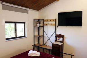 a bedroom with a flat screen tv on the wall at Casa do Maninho in Amarante