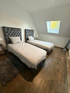 a bedroom with two beds and a window at La Clef des Champs in Mecquignies