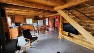 a living room with a television and a dining room at Domaine Valga in Saint-Gabriel