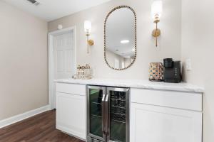 a kitchen with white cabinets and a mirror at GSU Getaway 4BR3BA spacious pet friendly in Statesboro