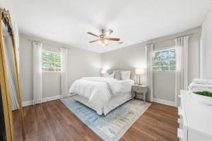 a white bedroom with a bed and a ceiling fan at GSU Getaway 4BR3BA spacious pet friendly in Statesboro