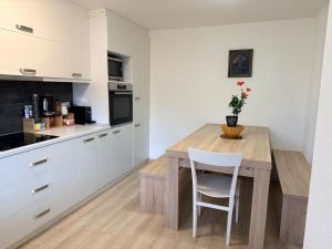 a kitchen with a wooden table and white cabinets at Ferienwohnung Winterzeit Thunersee&Mountainview in Thun