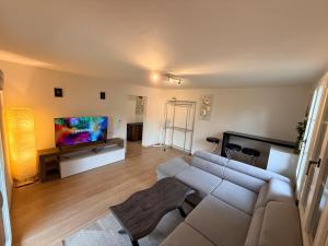 a living room with a couch and a flat screen tv at Ferienwohnung Winterzeit Thunersee&Mountainview in Thun