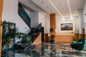 a lobby with a staircase and green chairs at Day Lux Superior Apartments in Sarandë