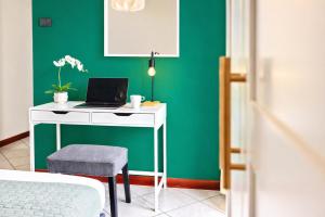 a desk with a laptop on a green wall at APPARTAMENTI LEONE - Vista Mare - Pet Friendly in Rimini