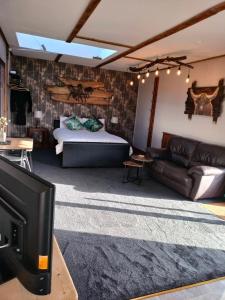 a living room with a bed and a couch at The Hideaway with hot tub in Chathill