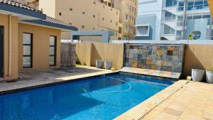 a large blue swimming pool in front of a building at The Folkestone Guest House in Gqeberha