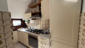 a small kitchen with a stove and a refrigerator at Appartamento Belvedere in Teglio +23 photos
