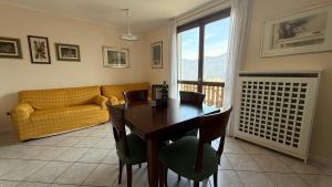 a living room with a table and chairs and a couch at Appartamento Belvedere in Teglio