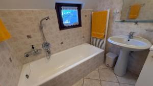 a bathroom with a sink and a bath tub and a sink at Appartamento Belvedere in Teglio